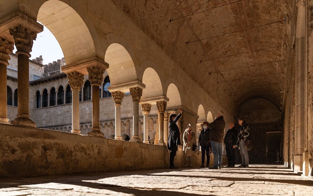 grup de persones visitant el claustre del monestir