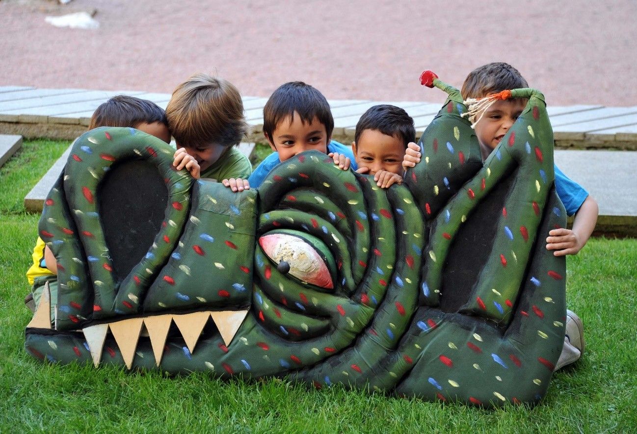infants jugant al pati del claustre amb la figura d'un drac
